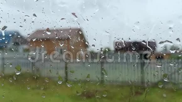 雨滴沿着乡间小屋窗户的玻璃流下夏天的雨灰暗的天空悲伤和孤独视频的预览图