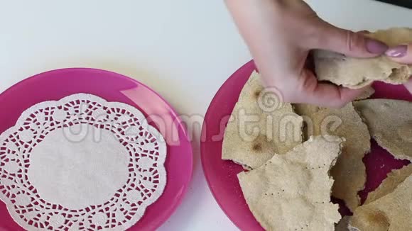 盘子上有一块新鲜的玉米饼女人把它们移到另一个盘子里视频的预览图