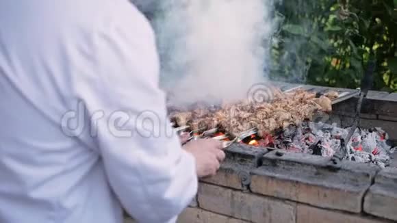 厨师在煤块上烤猪肉在烤架上烤猪肉从砖块上烤猪肉有烟视频的预览图