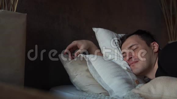 那个人在卧室里平静地睡觉放松一个平静平静的人睡在床上疲倦的人睡觉视频的预览图