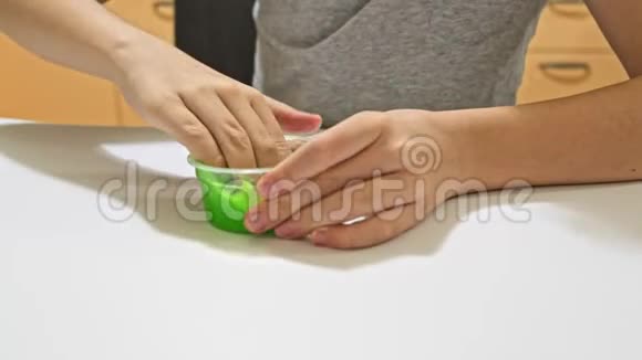 一个男孩玩绿色黏液孩子们精细的运动技能创造力和发展流行的抗压力玩具视频的预览图