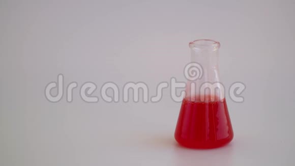 白色背景上带有液体的实验室玻璃器皿玻璃化学瓶试剂视频的预览图