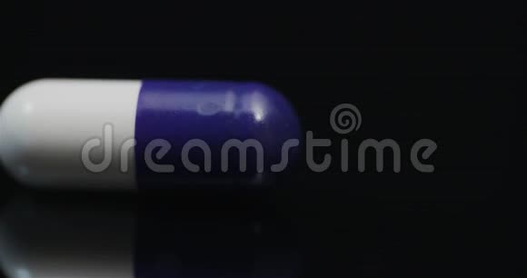 单药丸在黑色背景下旋转视频的预览图