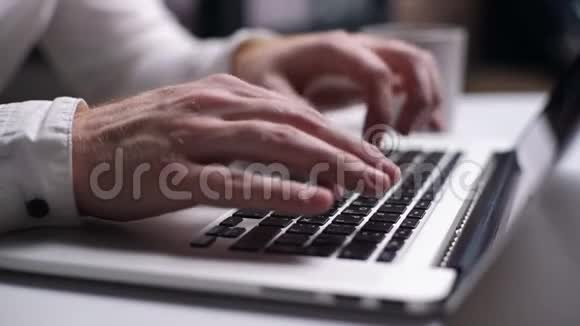 在家里的办公桌上男人用手在笔记本电脑键盘上打字视频的预览图