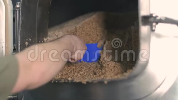 特写镜头一个男性酿酒师从啤酒酿造罐中提取废麦芽啤酒生产视频的预览图