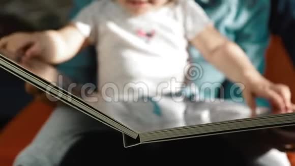 妈妈抱着一个孩子正在玩一本大书合上视频的预览图