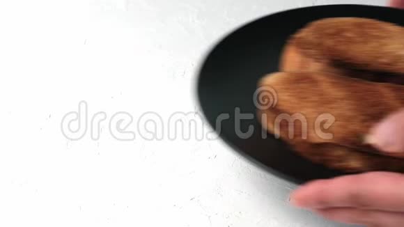 用白小麦粉做的两片油炸面包放在一个黑色的圆形盘子里手在放食物视频的预览图