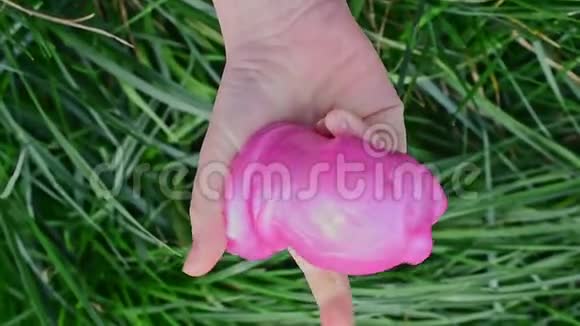一个小孩子手中拿着一个粉红色的黏液的俯视图视频的预览图
