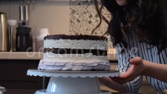 女孩在蛋糕上涂上奶油女孩把蛋糕和奶油搭配起来视频的预览图