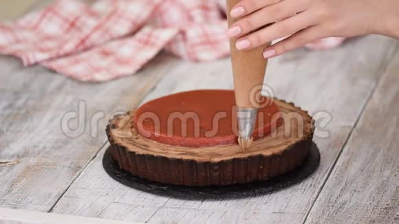 糖果师用樱桃糖果和巧克力奶油装饰美味的巧克力馅饼视频的预览图