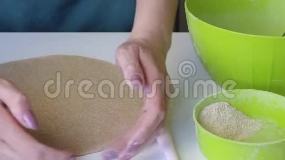 一个女人给面团蛋糕一个圆形借助双手和擀面杖容器旁边是面粉准备一个视频的预览图