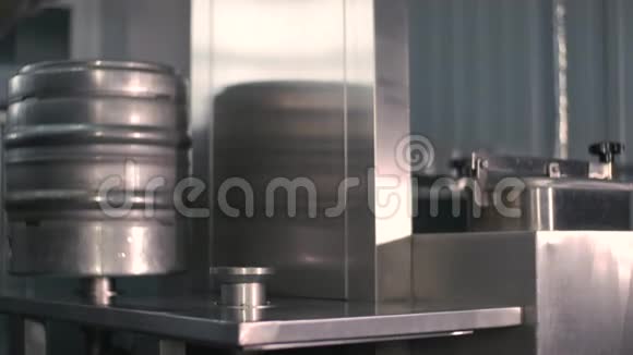 一名男性啤酒师使用自动啤酒桶灭菌机清洗和消毒啤酒桶特写视频的预览图