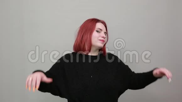 红头发的胖女人穿着黑色毛衣幸福的女人高兴地举起双手微笑视频的预览图