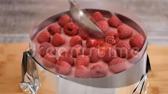 糕点厨师把红果冻倒在树莓蛋糕上视频的预览图