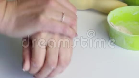 一个女人揉一块面团做新鲜蛋糕双手跪在桌面上准备无酵饼视频的预览图
