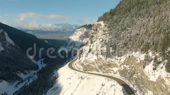 加拿大山景之间山谷中一条风景优美的公路的空中无人机景视频的预览图