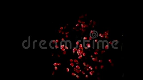 成熟的石榴汁般的红粒在黑色的背景上跳跃视频的预览图