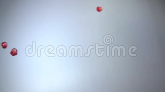 成熟石榴的汁粒斜落在白色背景上视频的预览图