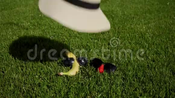 草莓太阳镜里的香蕉像游客一样在草地上休息帽子掉在他们身上视频的预览图