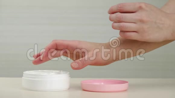 一个女人用奶油涂在她的手上受损的干燥皮肤上美人和健康的概念视频的预览图