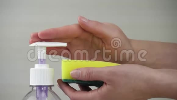 女人在海绵特写上打肥皂或洗碗液卫生和清洁一滴清洁剂在视频的预览图