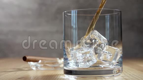带冰的玻璃杯里的威士忌慢动作视频的预览图