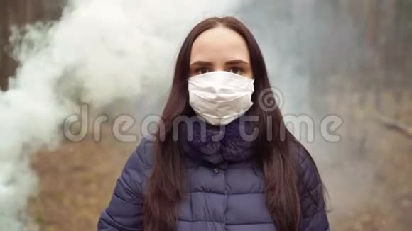 森林中戴着医用面具的年轻女子的肖像成年女性用面具遮住她的脸视频的预览图