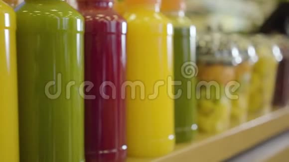商店货架上陈列着一排新鲜的果汁和五颜六色的干果相机在杂货店里沿着货物移动健康视频的预览图