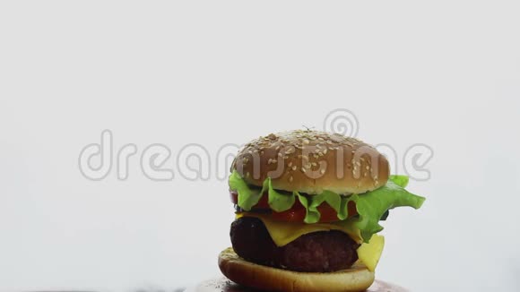 雄性手在新鲜多汁的汉堡上伸出拇指大的多汁汉堡有牛肉切新鲜蔬菜和融化的奶酪快餐视频的预览图