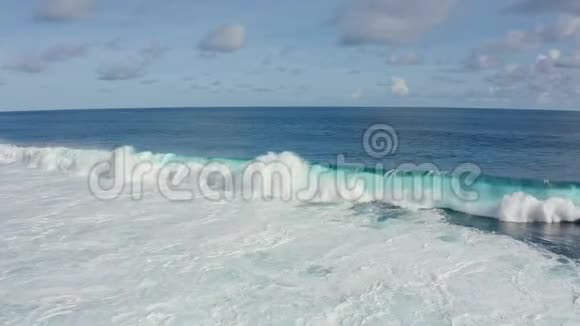 阳光明媚的一天带着美丽的泡沫滚滚海浪的蓝色海洋鸟瞰视频的预览图