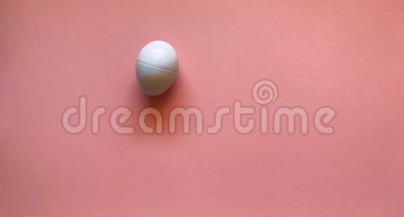 鸡蛋在浅粉色的背景上排成一排跳舞平躺复活节的概念停止运动动画视频的预览图