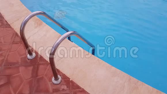金属梯子到游泳池游泳池里是清澈的蓝色水视频的预览图