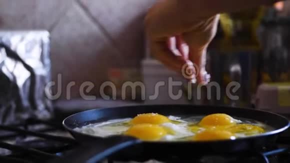 煎鸡蛋在锅上女孩正在给鸡蛋上盐视频的预览图