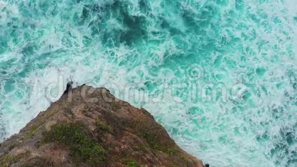 美丽的蓝色海浪环绕着高棕色的岩石视频的预览图