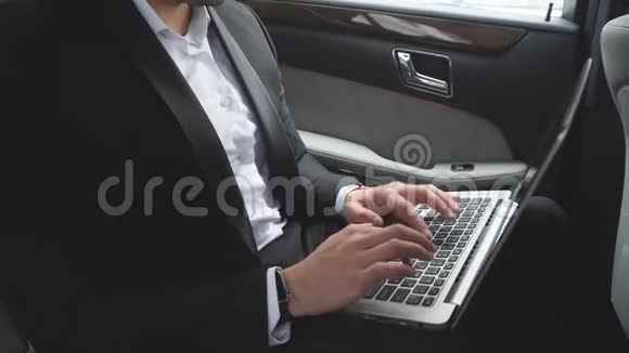 男性穿着豪华车的笔记本电脑视频的预览图