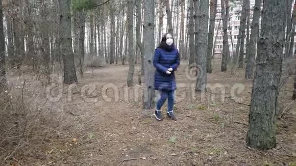 戴着医用口罩的年轻女子在森林里逃离病毒成年女性戴着面罩视频的预览图