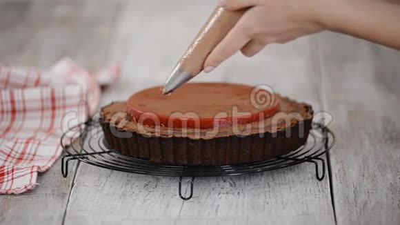 糖果师用樱桃糖果和巧克力奶油装饰美味的巧克力馅饼视频的预览图