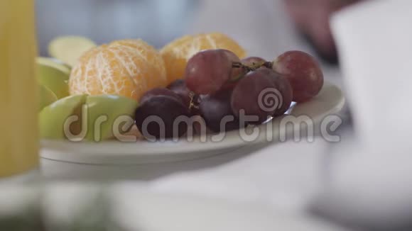 盘子的特写水果站在桌子上女性白种人手拿一颗葡萄无法辨认的妇女视频的预览图