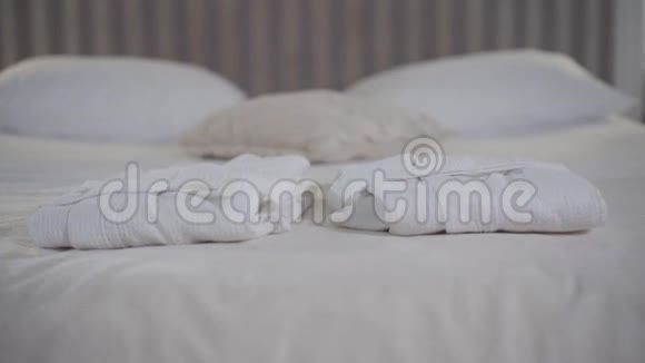 酒店客房内柔软的大床上躺着两条雪白毛巾为客人提供住宿的卧室视频的预览图