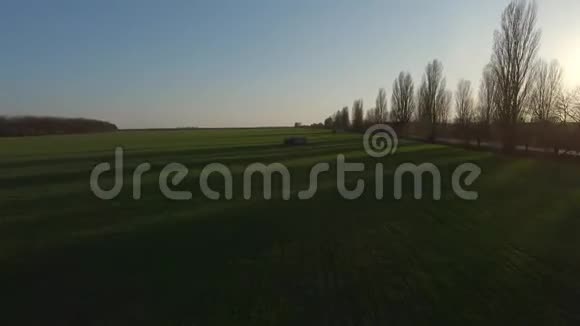 在日落时分在年轻的小麦上方观看FPV无人机视频的预览图