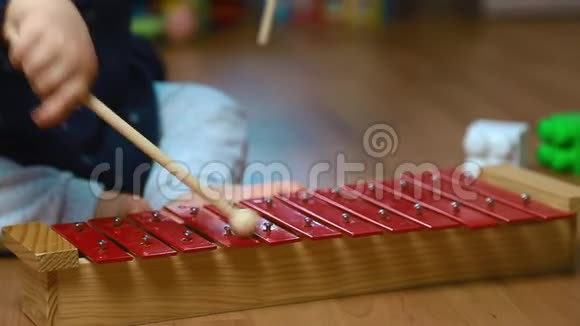 孩子在红色木琴上玩棍子打击乐器关门视频的预览图