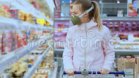 戴防护面罩的女孩在超市精心挑选产品检疫冠状病毒安全措施视频的预览图