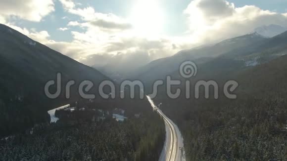 加拿大山景之间山谷中一条风景优美的公路的鸟瞰图视频的预览图