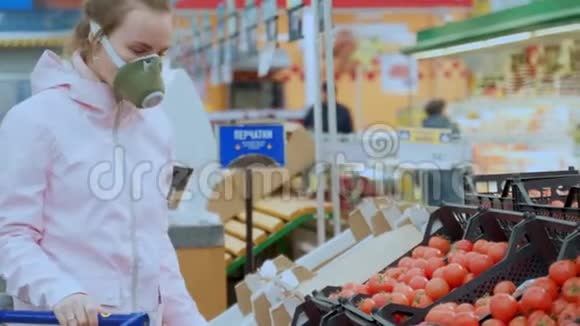 一名戴防护面罩的妇女在超市精心挑选蔬菜采取检疫冠状病毒安全措施视频的预览图