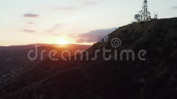 在美丽的日落黄金时间灯光下的好莱坞山和洛杉矶山边的好莱坞标志上的风景视频的预览图