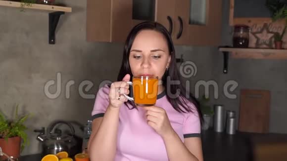 年轻迷人的女人在厨房喝橙汁迷人的女性在晚上享受清爽的饮料的肖像视频的预览图