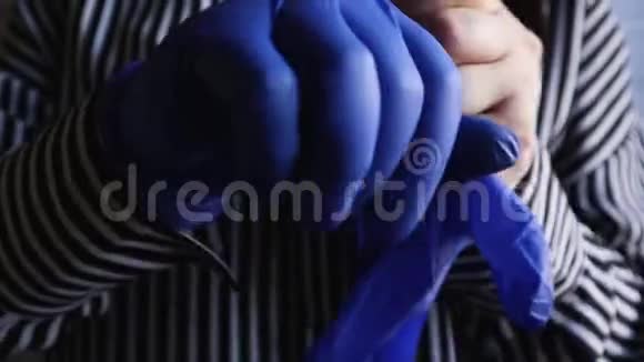 戴上蓝手套的妇女的双手以防止病原体的传播从而保护自己免受疾病的爆发和流行视频的预览图