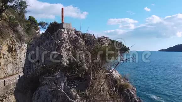 滑无人驾驶飞机在群山之间沿着海岸在酒店前面飞行视频的预览图