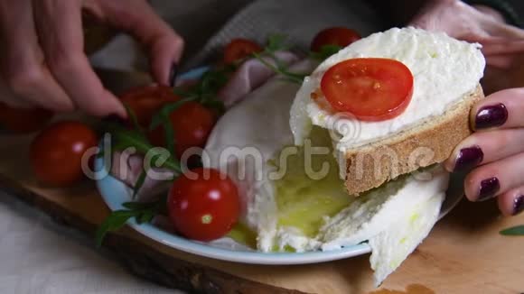 女性的双手正在放一片新鲜的马拉和一片番茄面包意大利普利亚的食物当地的美食视频的预览图