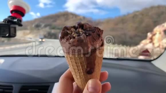 华夫饼锥与巧克力冰淇淋由某人在移动汽车视频的预览图